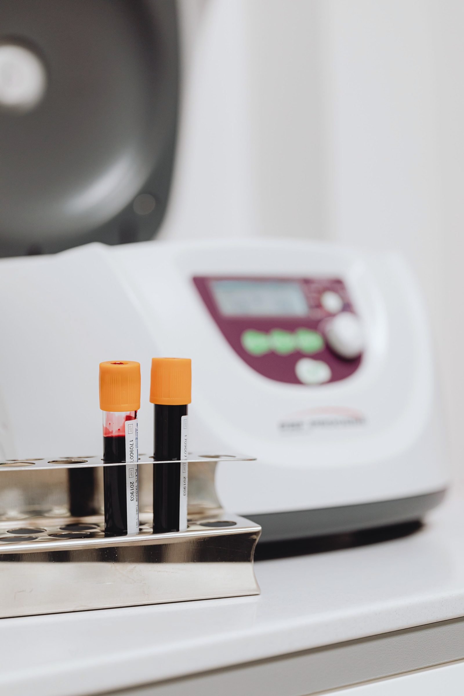 Two capped sample tubes in a rack beside a benchtop centrifuge