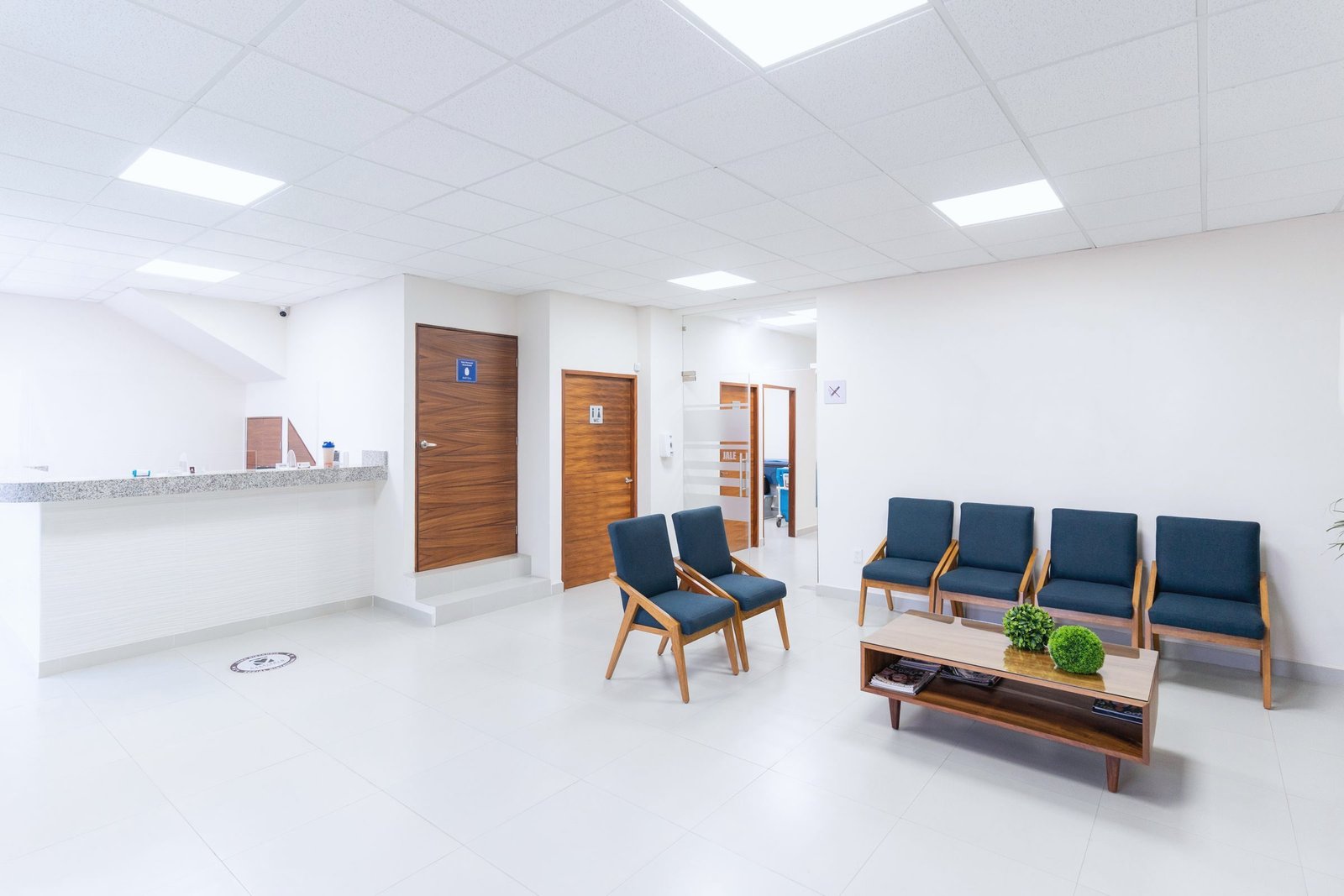A quiet clinic waiting area with empty chairs and a reception counter